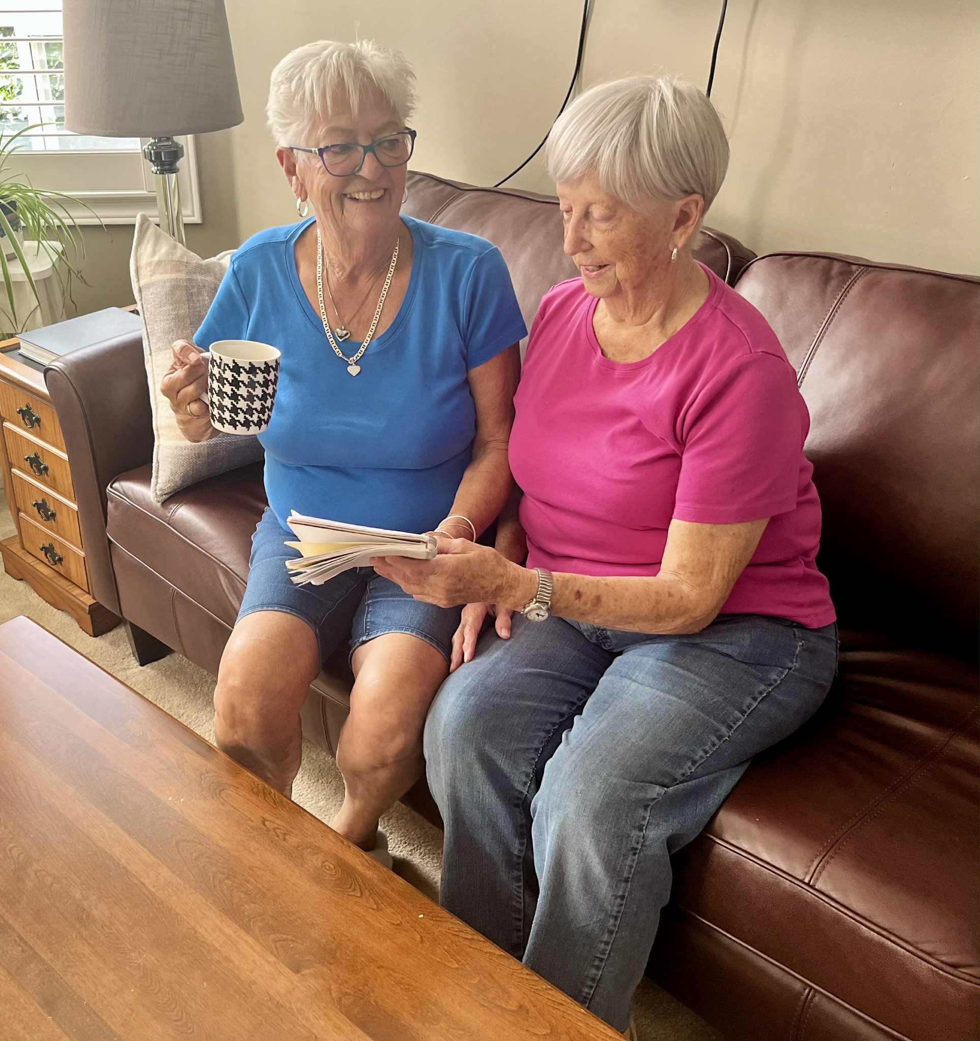 Two smiling seniors enjoying tea and conversation